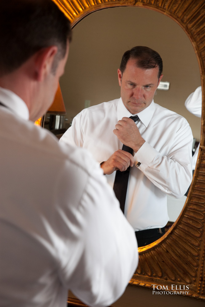 Groom reflected in mirror as he adjusts his tie before wedding at the Sorrento Hotel