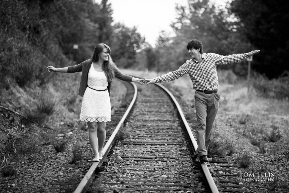 Trevor and Aurora try to balance and walk on the old train tracks near the Wilburton trestle during their engagement photo session