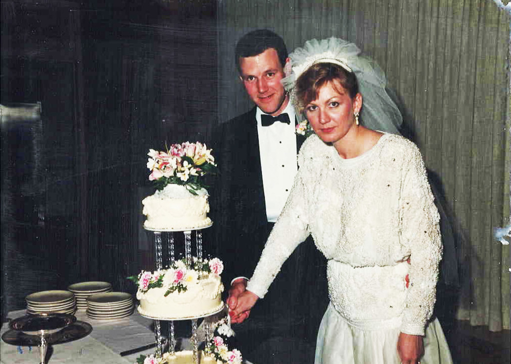 Photo of bride and groom preparing to cut their wedding cake