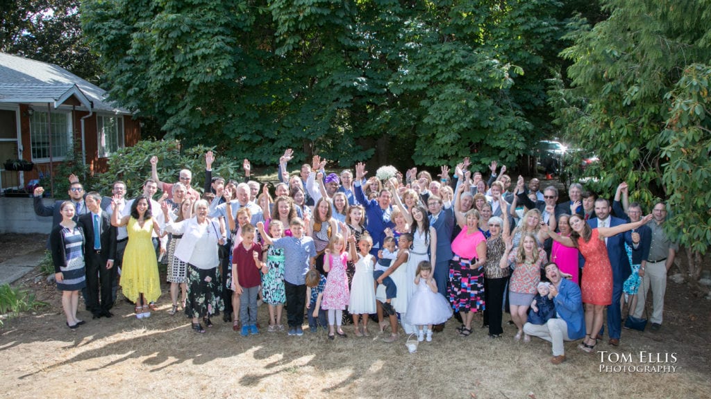 Seattle area wedding photography. Group photo of the bride, groom, wedding party and all of their guests immediately after the conclusion of their wedding ceremony. The entire wedding and reception were all held at their home in Normandy Park.