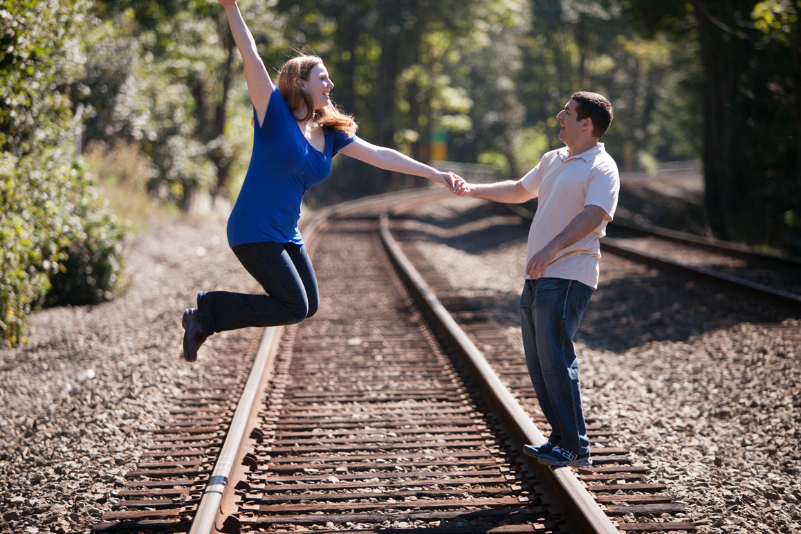 Rachel & Brett having fun on the train tracks during their Seattle engagement photos at Golden Gardens