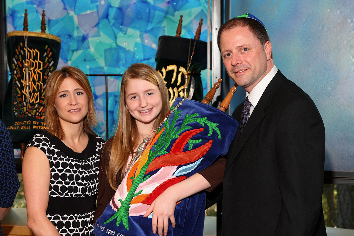 Rachel and parents with torah at Bellevue Bar Mitzvah at Temple de Hirsh Sinai