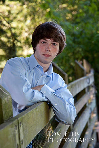 Photo of senior boy leaning on fence at Robinswood Park in Bellevue