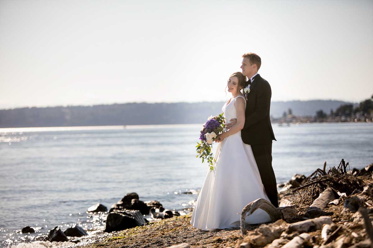 Seattle wedding photographer Tom Ellis Photography. Bride and groom wearing Happy New Year hats hug outside the Lake Union Cafe at their New Year's Eve wedding