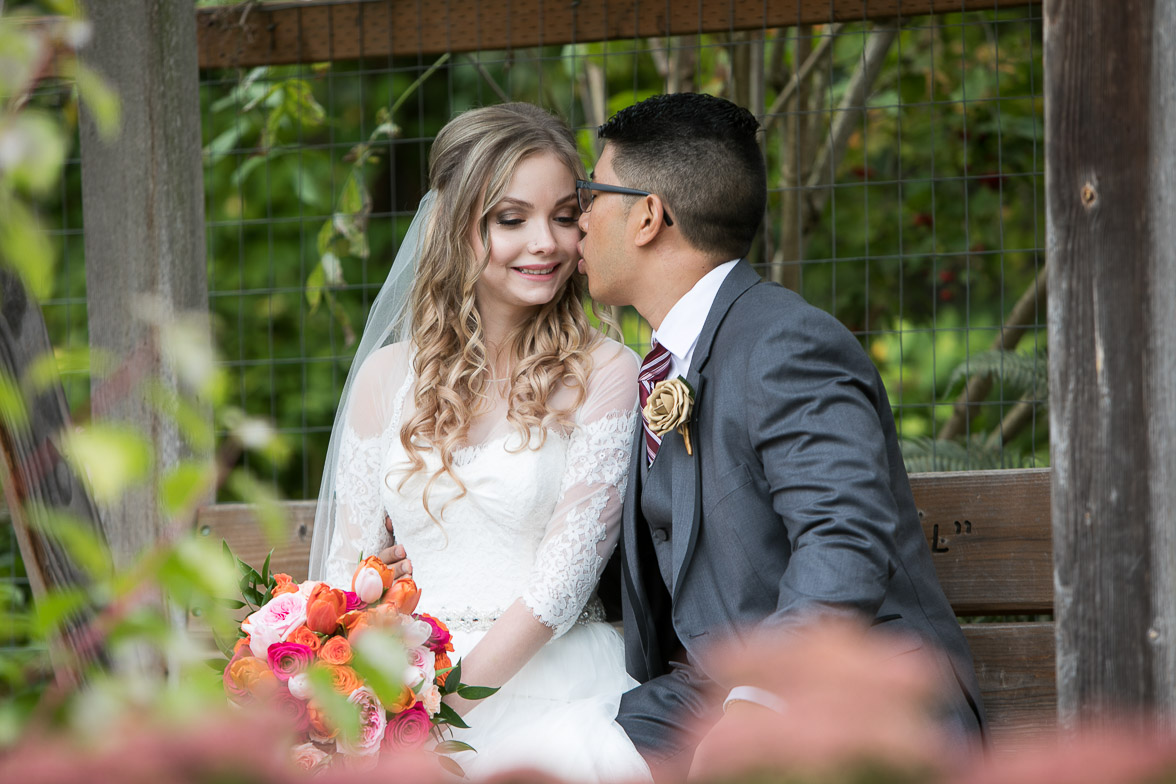 Seattle wedding photographer Tom Ellis Photography. Bride and groom on a bench on a beautiful garden during ther pre-ceremony photo session in Marysville WA