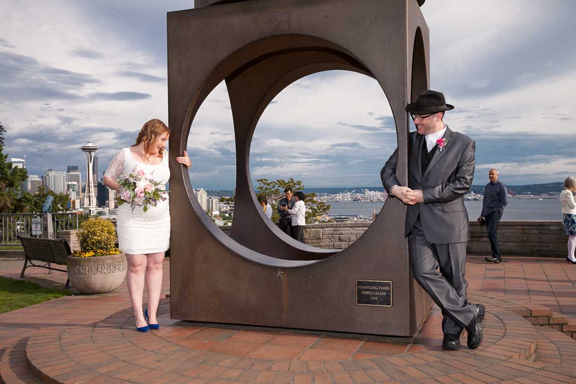 Seattle wedding photographer Tom Ellis Photography. Bride and groom playing around on the sculpture at Kerry Park in Seattle