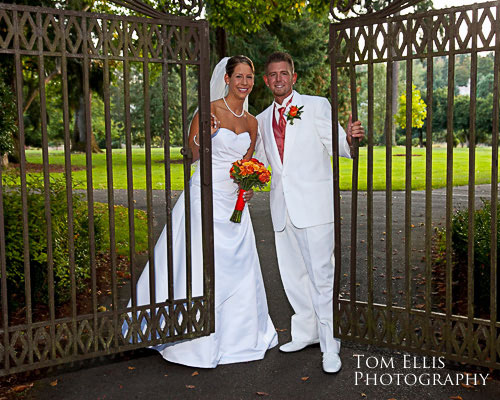 Bride and groom standing at the gates of Clise Mansion, at Marymoor park in Redmond