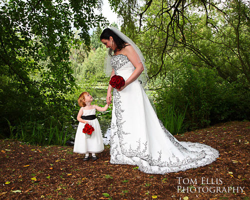 Bride and flower girl near pond during wedding at Robinswood House