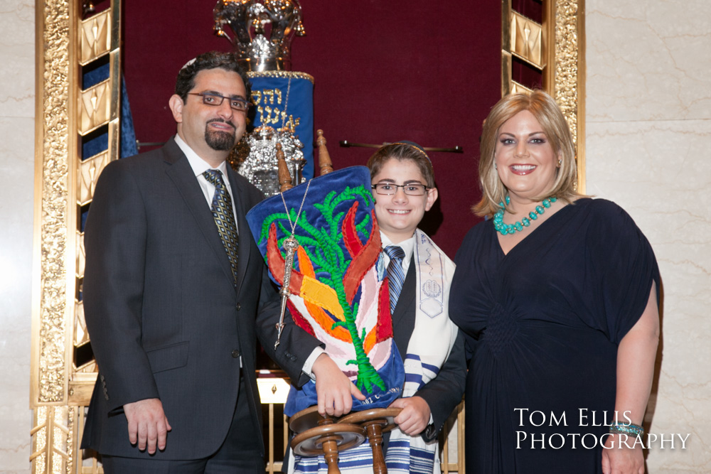 Young Bar Mitzvah poses with his parents while he holds the Torah, at Temple de Hirsch Sinai in Seattle