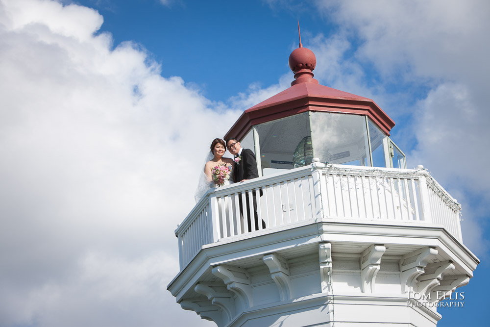 Bride and groom pose for a photo on the catwalk at the top of the Mukilteo Lighthouse