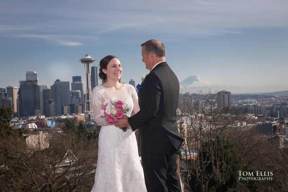 Bride and groom pose at Kerry Park in Seattle, with backdrop of the Space Needle and Mt Rainier