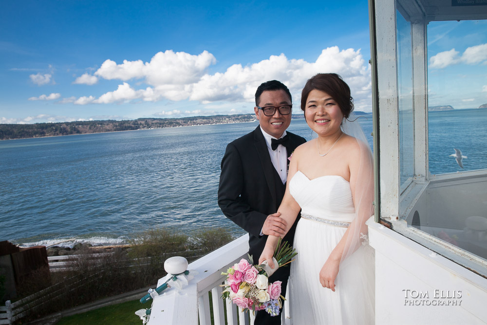 Bride and groom stand on the catwalk at the top of the Mukilteo Lighthouse