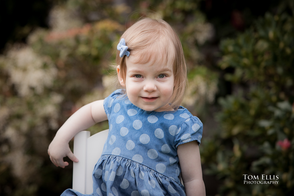 Seattle area family photo session with 18 month old Emily, as she poses in front of her house