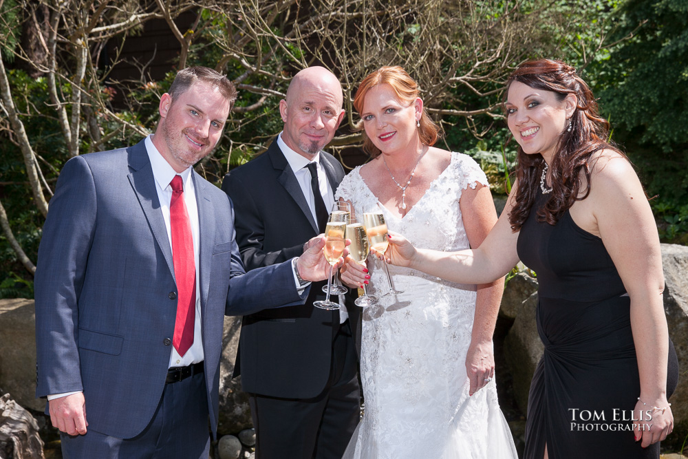 Bride and groom raise their glasses is a toast with the best man and maid of honor