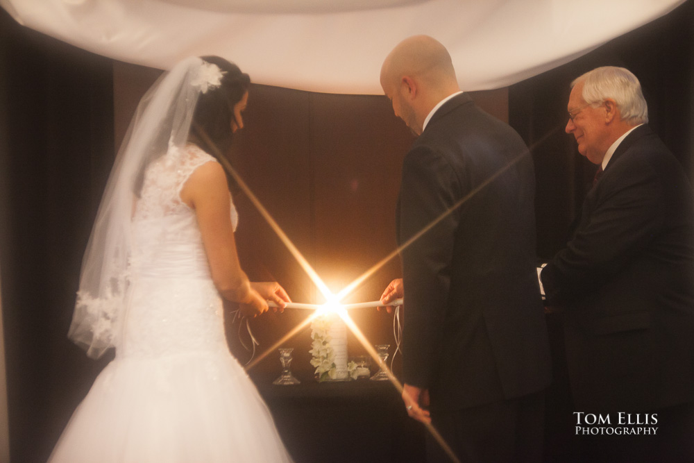 Bride and groom light their unity candle during their wedding ceremony at the W Hotel in Seattle