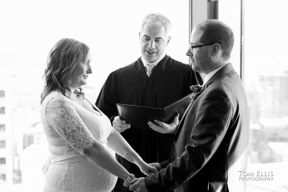 Bride and groom hold hands during their wedding ceremony at the Seattle Municipal Courthouse