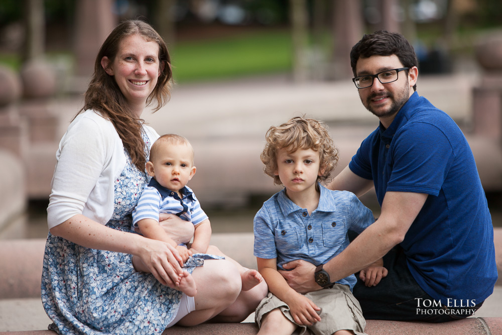 Mom, Dad and their two young sons sit on a bridge over the canal in Bellevue Park