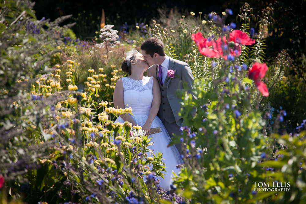 Bride and groom kiss in a beautiful flower garden