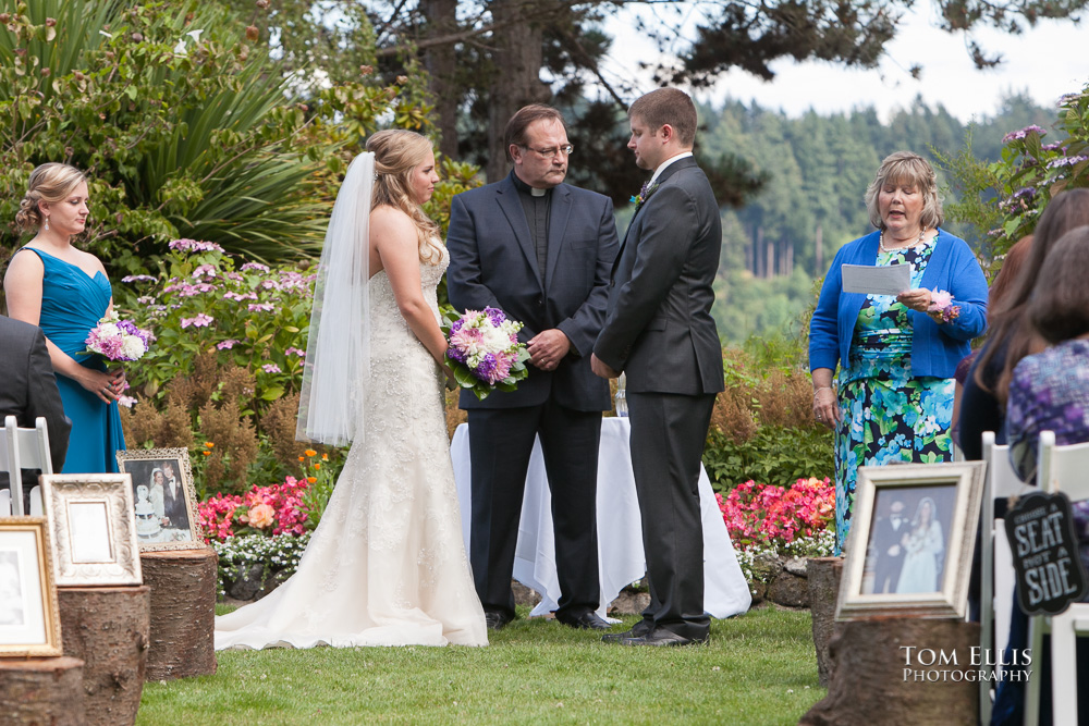 Bride and groom stand with the wedding officiant during their wedding ceremony at Kiana Lodge