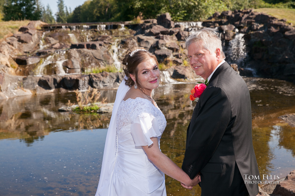 Bride and groom in front of the waterfall and pond at Echo Falls Golf Club