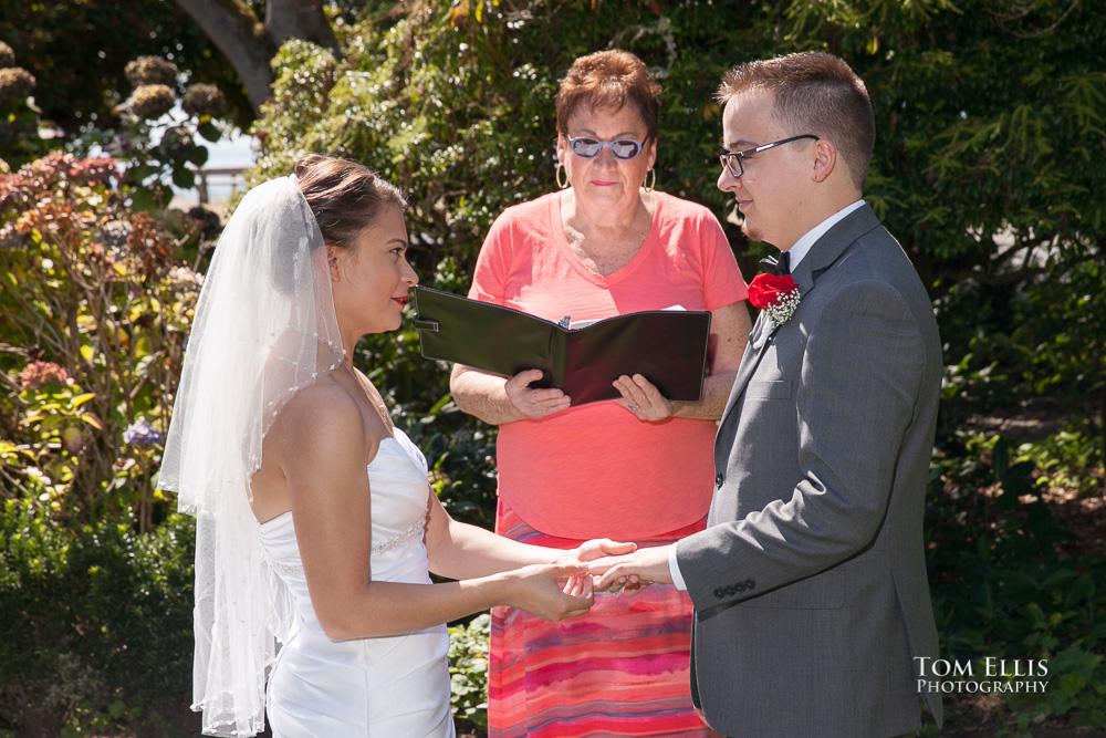 Couple standing with their wedding officiant in a beautiful park for their elopement