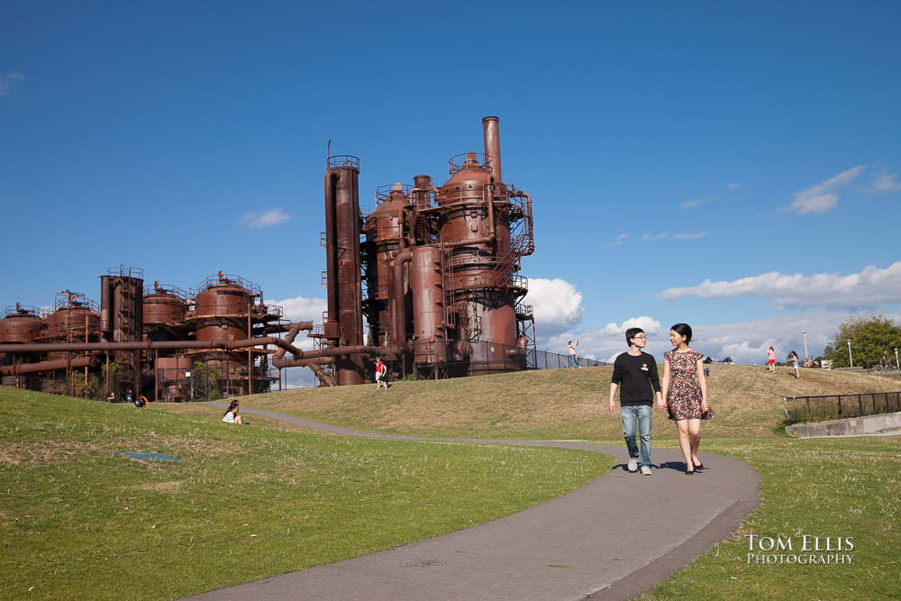 Couple walk hand in hand during their Seattle engagement photo session at Gasworks Park