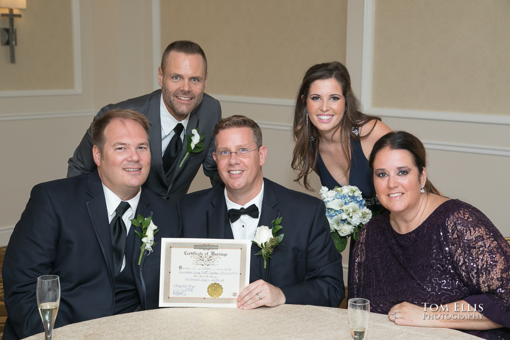 Gay couple and their witnesses and officiant show off their wedding certificate