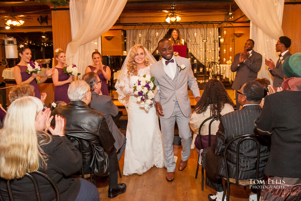 Bride and groom recess down the aisle at the conclusion of their Seattle wedding ceremony at the Lake Union Cafe