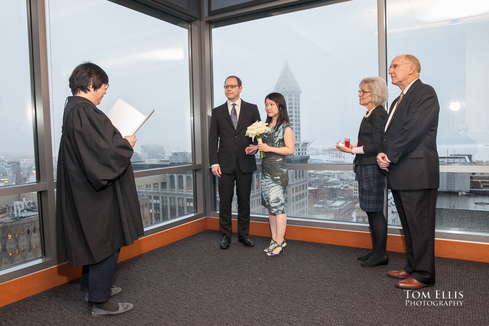 Bride and groom, along with the groom's parents, stand with the judge during their wedding ceremony at the Seattle Municipal Courthouse