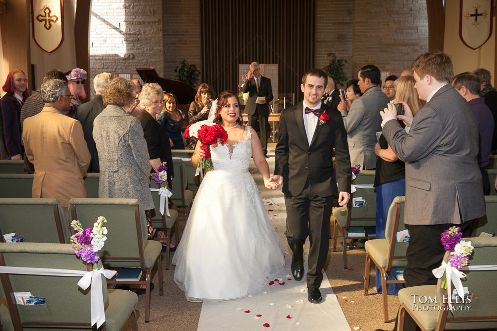 Bride and groom coming down the aisle at the conclusion of their Seattle wedding by Tom Ellis Photography