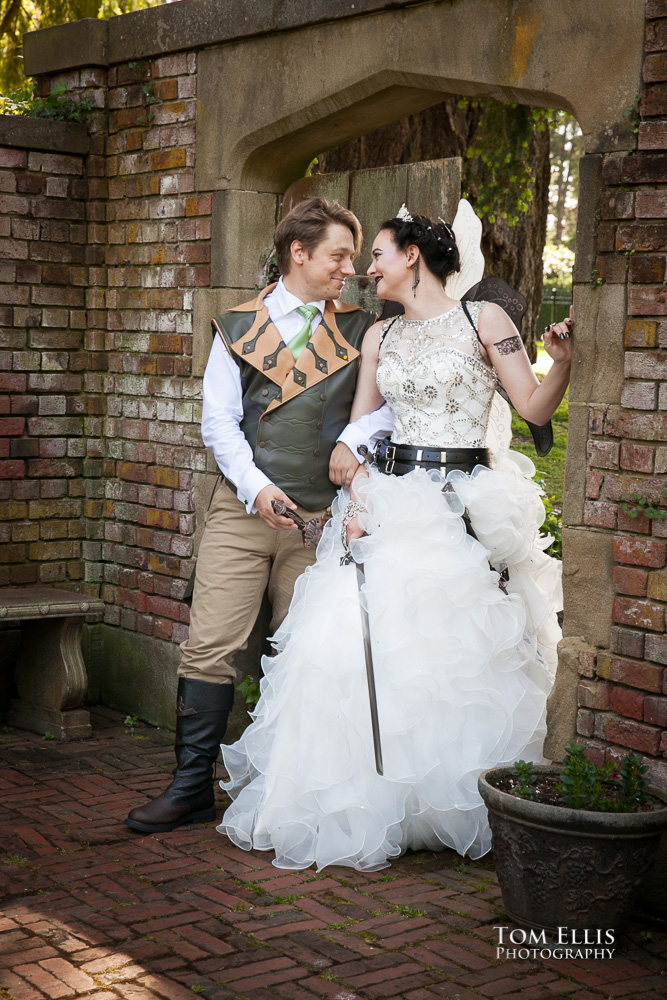 Bride and groom in Dresden File inspired costumes pose for a photo in the formal garden at Thornewood Castle