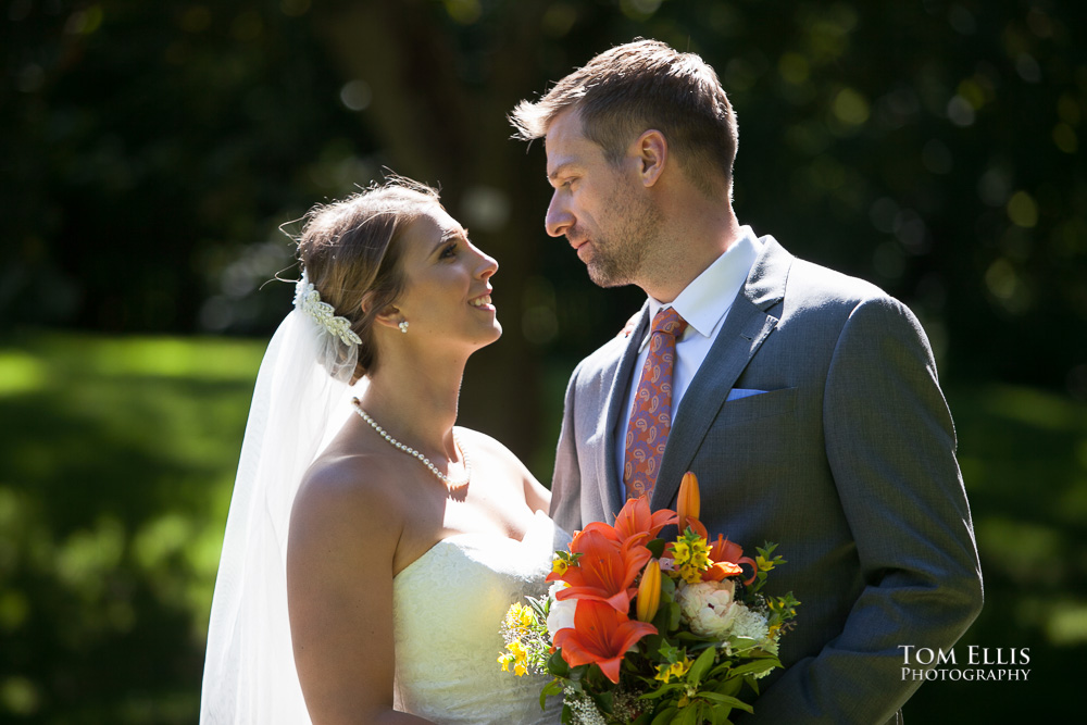 Beautifully backlit close up photo of bride and groom, with a forest backdrop