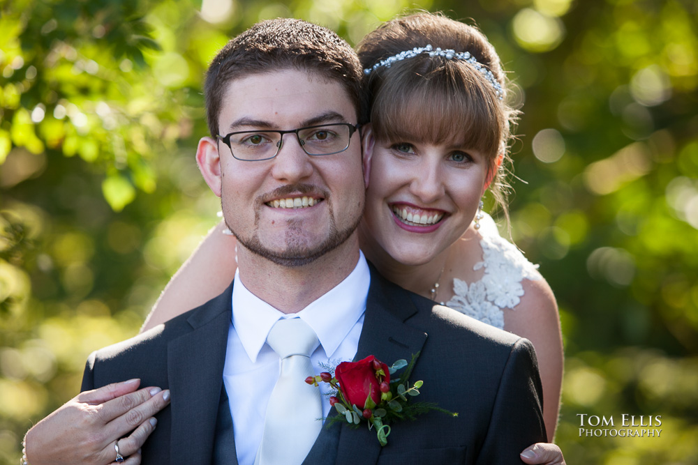 Close up photo of bride and groom as the bride hugs the groom from behind