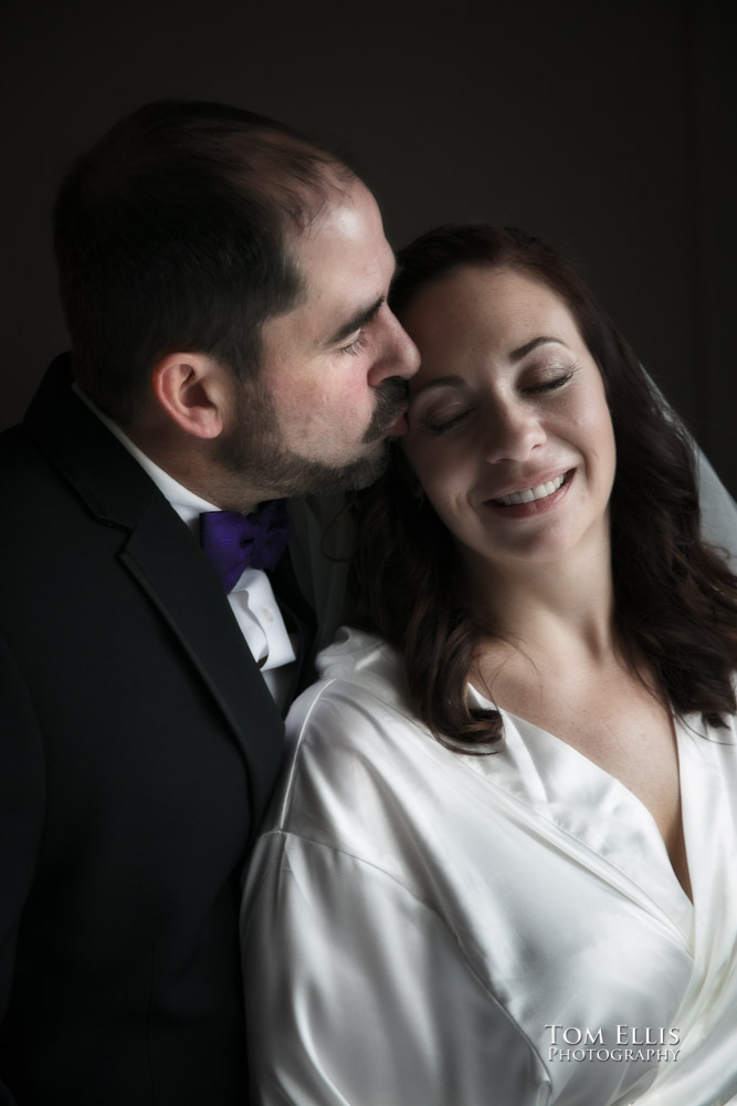 Beautiful romantic photo of groom kissing bride on the forehead shortly before their wedding ceremony. Tom Ellis Photography