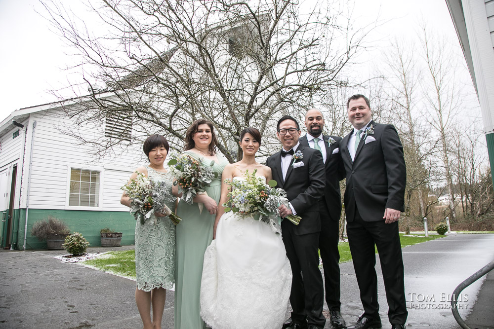 Bride, groom and their wedding party pose for a photo in the snow outside Russell's Loft