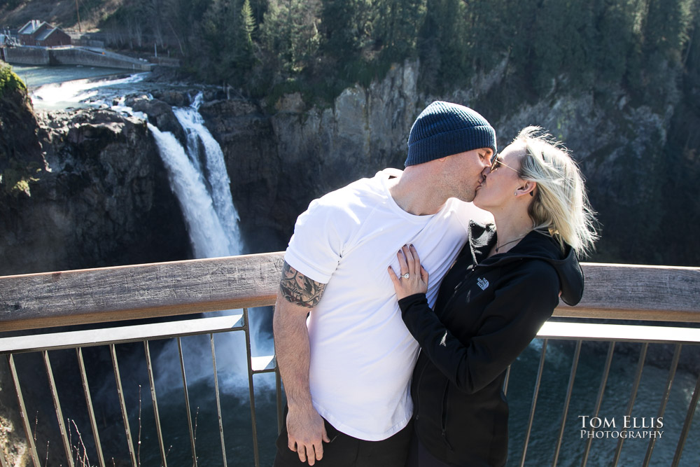 Andrew and Julia kiss with Snoqualmie Falls in the background, during their surprise proposal and engagement photo session