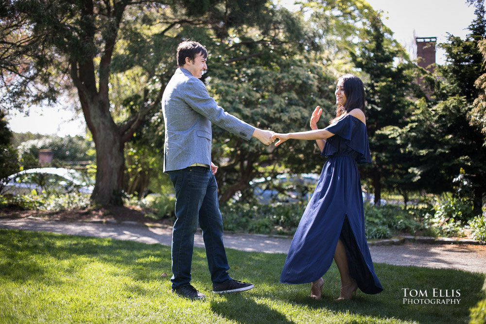 Engaged couple dances together in Kerry Park during their engagement photo session