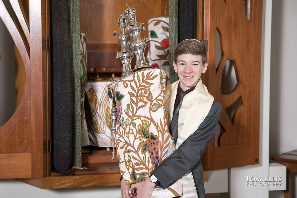 Ben poses with the torah in front of the open ark at his Bar Mitzvah