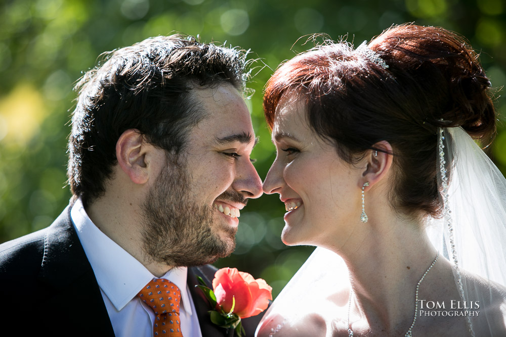 Close up photo of bride Angie and groom David as they face each other nose to nose before their wedding ceremony at Willows Lodge. Tom Ellis Photography.