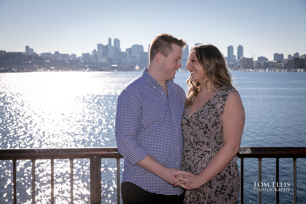 Kate and Kevin pose for a photo along Lake Union with the Seattle skyline for a backdrop at Gas Works Park, by Tom Ellis Photography