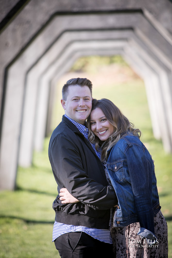 Kate and Kevin share a laughing hug under the old arches during their engagement photo session at Gas Works Park