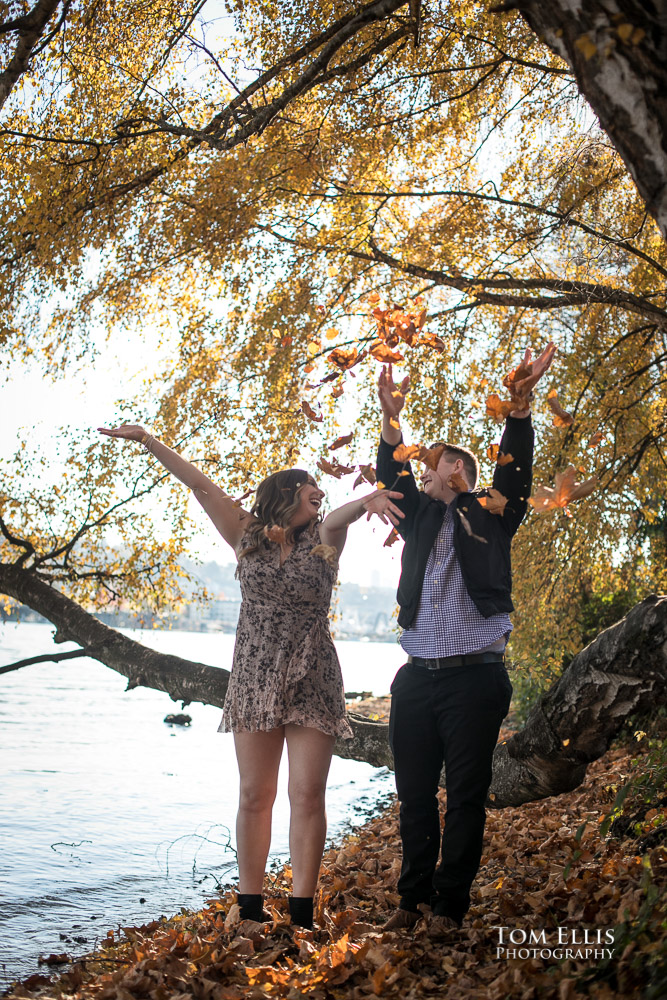 Kate and Kevin throw leaves in the air during their engagement photo session at Gas Works Park