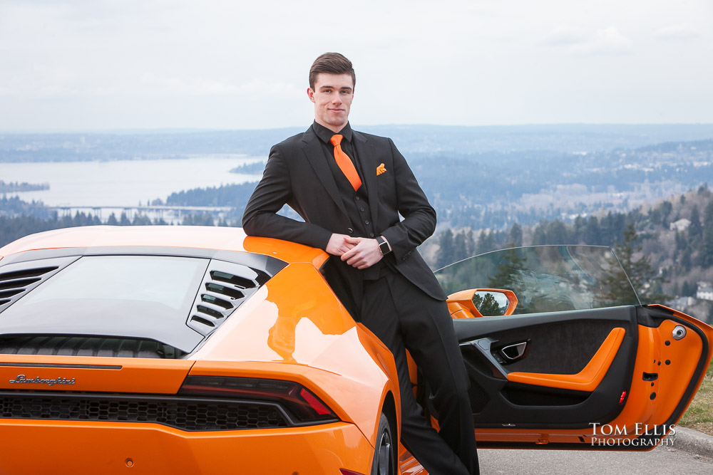 Luke all in black leans against his orange Lamborghini with open door during his senior photo session at Newcastle Golf Club. Tom Ellis Photography, Seattle senior photographer