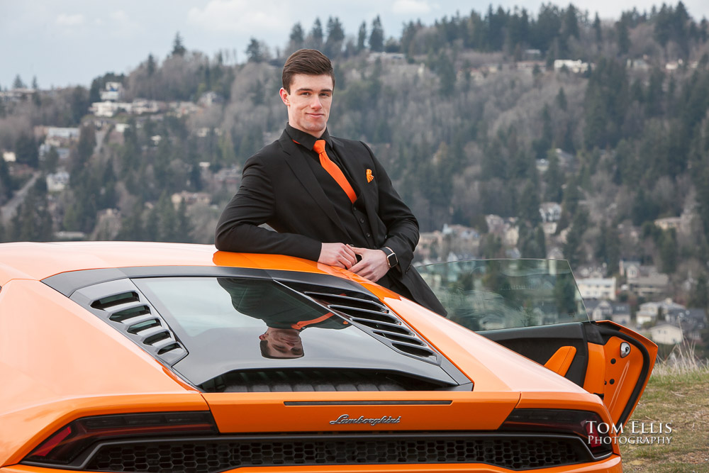 Close up of Luke all in black with an orange tie leaning on his orange Lamborghini during his senior photo session at Newcastle Golf Club. Tom Ellis Photography, Seattle senior photographer