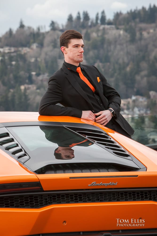 Close up of Luke all in black with an orange tie leaning on his orange Lamborghini during his senior photo session at Newcastle Golf Club. Tom Ellis Photography, Seattle senior photographer