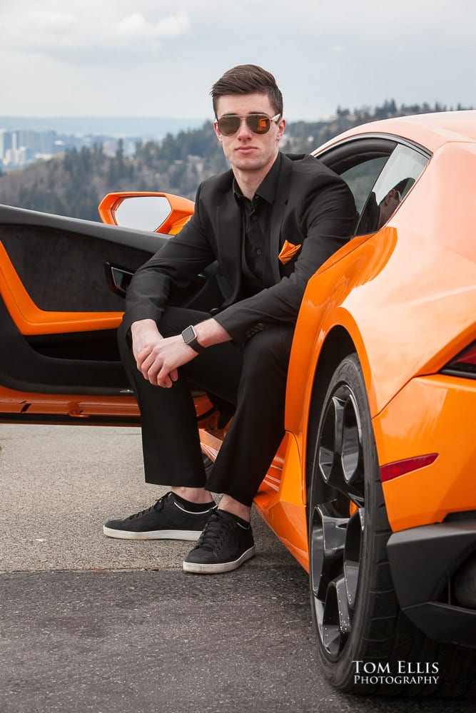 Close up of Luke all in black with an orange tie sitting in his orange Lamborghini during his senior photo session at Newcastle Golf Club. Tom Ellis Photography, Seattle senior photographer