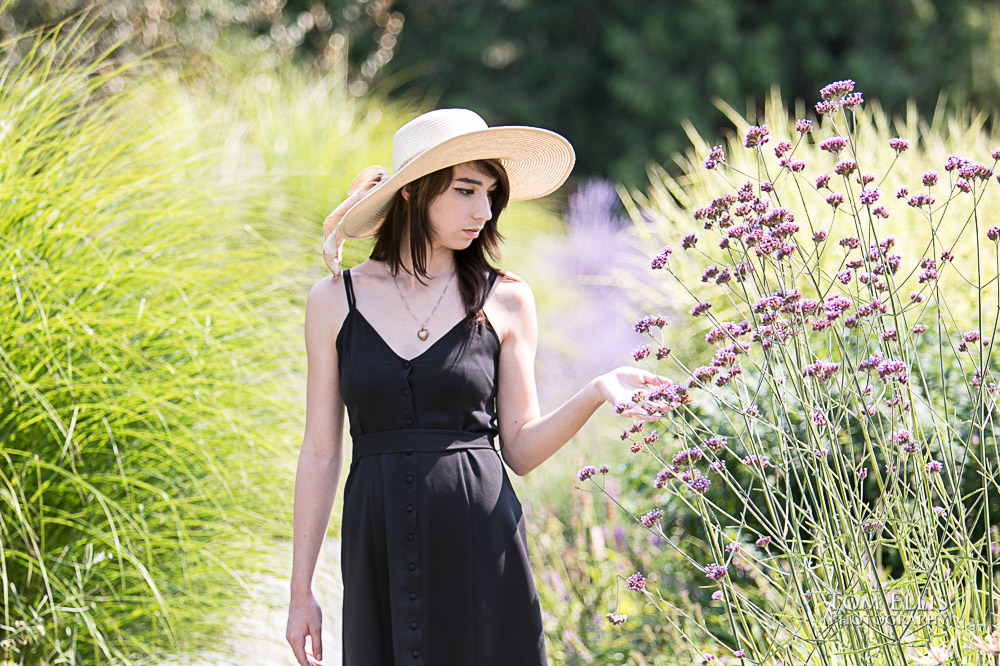 Beautiful high school senior girl walking in a flower garden during her senior photo session at Bellevue Botanical Gardens