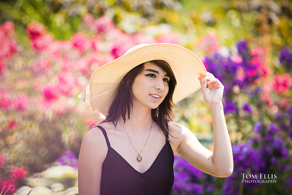 Beautiful high school senior girl surrounded by flowers during her senior photo session at Bellevue Botanical Gardens