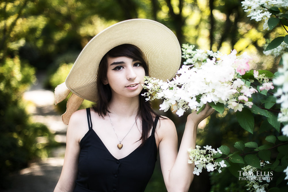 Beautiful high school senior girl in a very cool hat during her senior photo session at Bellevue Botanical Gardens