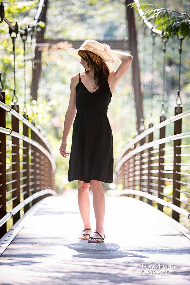 Beautiful high school senior girl walking on a suspension bridge during her senior photo session at Bellevue Botanical Gardens